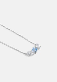 Collana d'argento con tre gemme: due pietre chiare a forma di pera e una pietra quadrata blu, montate su una catena delicata.