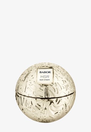 Contenedor redondo dorado con superficie texturizada y etiqueta blanca que dice "Babor HSR eye cream". La tapa se separa por la mitad.