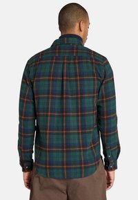 Geruite shirt in groen, blauw en oranje kleuren; lange mouwen; knopenmanchetten; textiel met structuur; afgeronde zoom; rugpas functie.