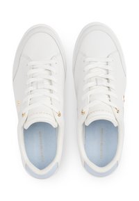 Hvite joggesko laget av glatt lær med rund tå, gullfargede metallaccenter og lyseblå innleggssåler. Snøringene er hvite og teksturerte.