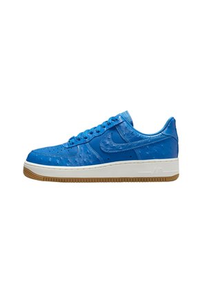 Nike Air Force 1 albastre cu un superior din piele texturată, talpă intermediară albă și talpă din cauciuc de gumă, având sistem de închidere cu șireturi.