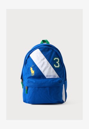 Sac à dos bleu avec une bande diagonale blanche, une poignée verte, le numéro trois en vert et blanc, et un logo joueur de polo jaune sur la poche avant.