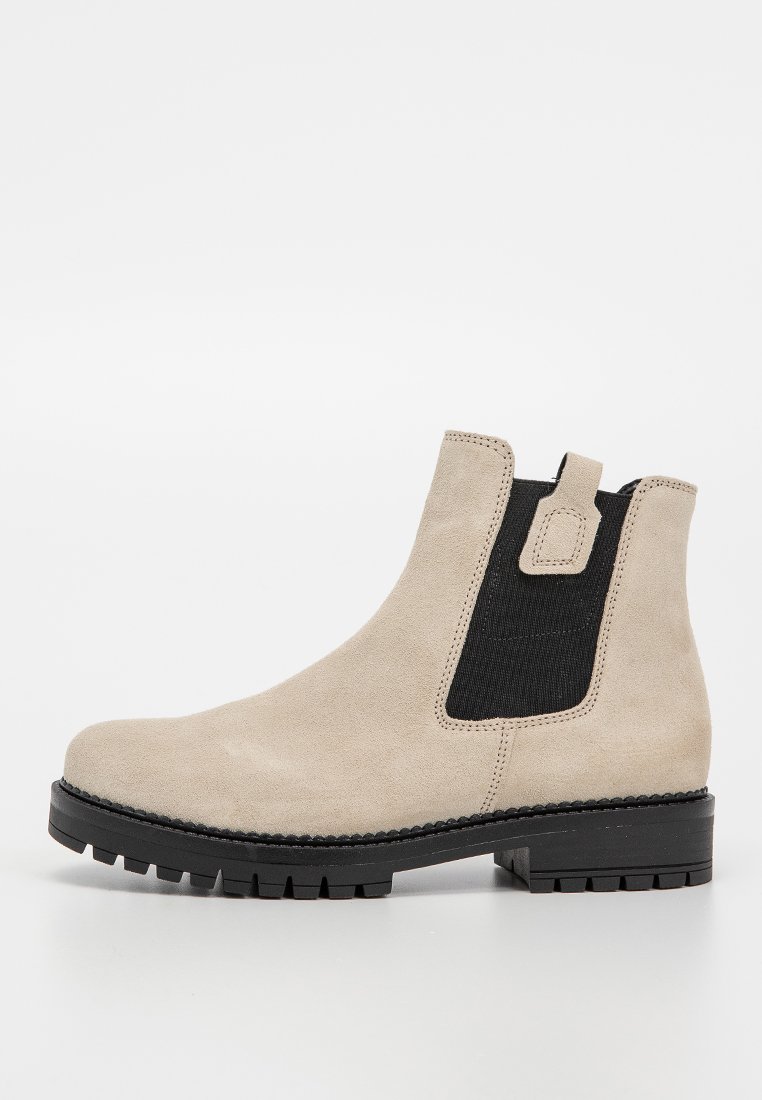 Beige Wildlederschuh mit schwarzen elastischen seitlichen Einsätzen, runder Zehenpartie und Gummisohle mit strukturiertem Profil.