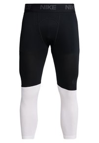 Black compression leggings with a white lower section, featuring a textured design, elastic waistband with "NIKE" branding, and a seamless cut.