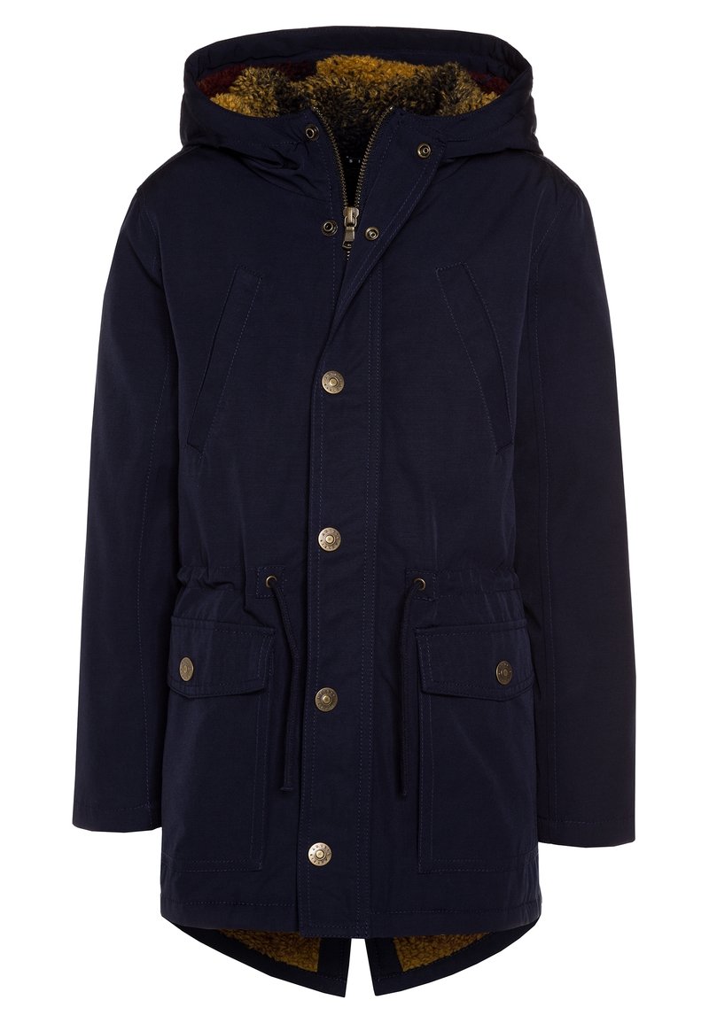Námořnická voděodolná parka s kapucí podšitou umělou kožešinou, se zipovým zapínáním a stahovacími šňůrkami v pase. Obsahuje zlaté knoflíky a dvě přední kapsy.