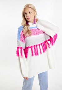 Barvna oversized pulover z mešanico rožnate, modre, sivo in bele vzorce, z rožnatimi resami vzdolž roba. Mehak tekstura.
