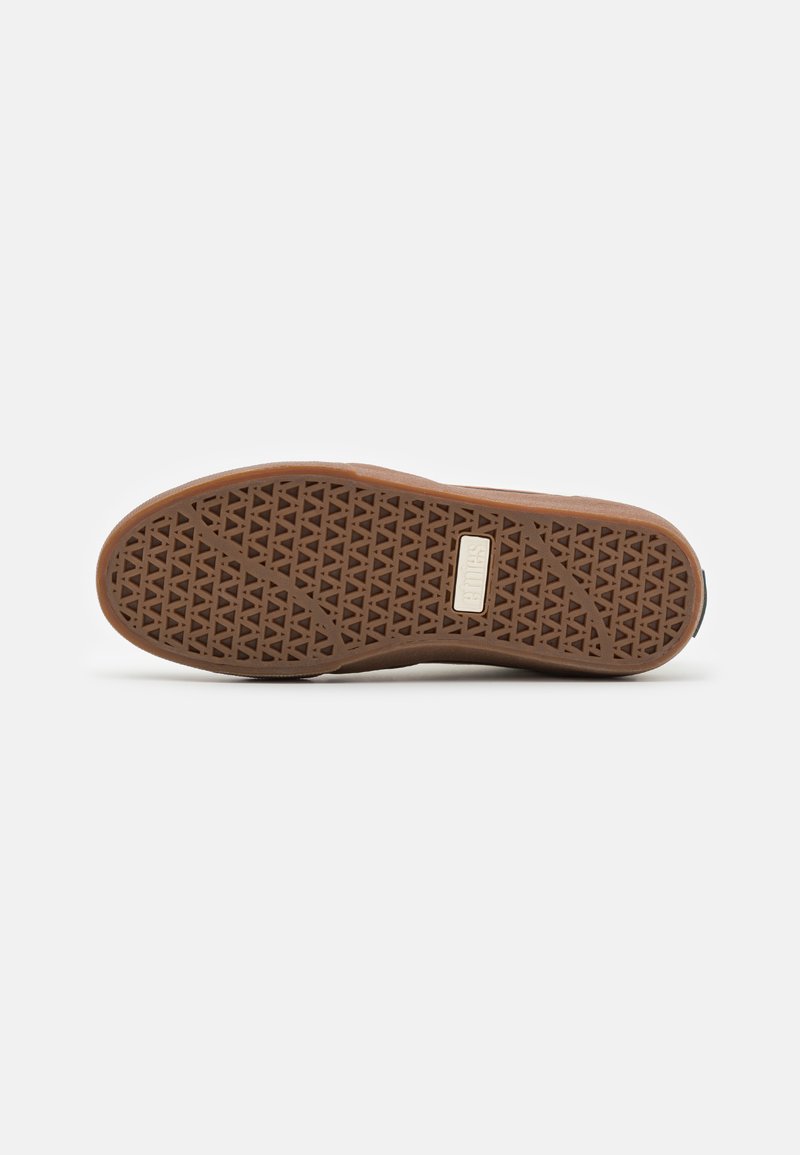 Brauner Gummi-Schuhsohle mit einem strukturierten Muster, das ein geometrisches Design aufweist, und einem rechteckigen Markenetikett nahe der Ferse.