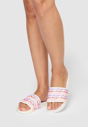 Chanclas blancas de estilo slide con múltiples logotipos de colores (rosa, morado, azul) en las cintas anchas. Suela plana con un diseño de punta abierta.