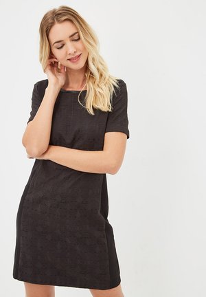 Vestido negro de manga corta con un patrón geométrico texturizado en el frente y tejido liso en los laterales, con un escote redondo.
