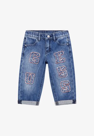 Blauwe denim jeans met een lichte wassing, voorzien van grote geborduurde letters 'G', 'U', 'E', 'S', 'S' in contrasterende kleuren aan de voorkant.