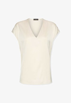 Kremowa bluzka z krótkim rękawem, z głębokim dekoltem w kształcie litery V i luźnym krojem, wykonana z gładkiej tkaniny, przedstawiona na białym tle.