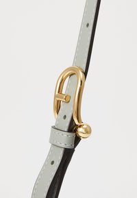 Cintura in pelle grigia con accenti neri, dotata di una chiusura in metallo dorato e dettagli di cucitura. Texture liscia e finitura lucida.