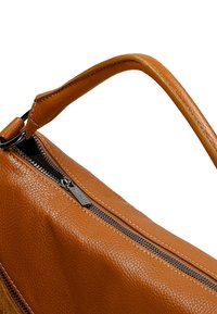 Braune Lederhandtasche mit texturierter Oberfläche, ausgestattet mit einem Reißverschluss und einem stabilen Griff. Akzentuiert mit schwarzem Reißverschluss-Zubehör.