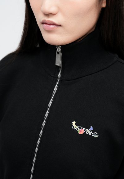 Čierna mikina so zipsom a vysokým golierom, na ktorej je vyšitý logotyp "Off-White™" a kvetinové akcenty na ľavej strane hrudníka. Metalický detail zipsu.