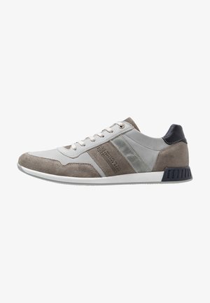 Sportowe sneakersy w szaro-szarym zamszu i skórze. Posiadają teksturowane akcenty, zaokrąglony czubek, płaską białą podeszwę oraz detal z logo z boku.