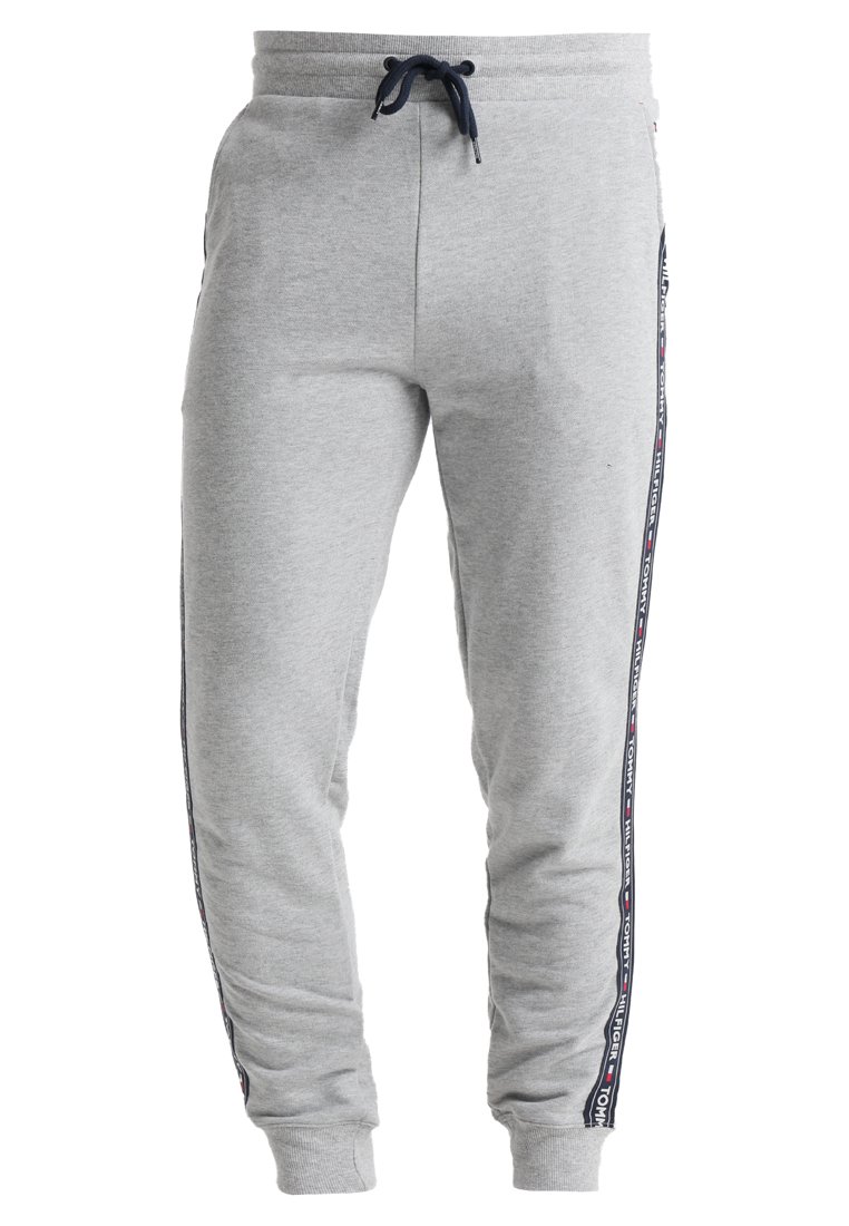 Lichtgrijze sweatpants van een zachte katoenen mix, met een trekkoord, taps toelopende pijpen en zwarte zijstrepen met rode en witte accenten.
