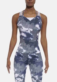 Zestaw topu sportowego i legginsów w niebiesko-białe-czarne wzory w kształcie plastra miodu. Posiada konstrukcję z paskami oraz teksturowany materiał zapewniający elastyczność.