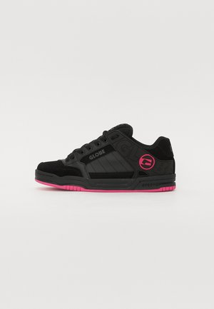 Schwarze Skaterschuhe mit pinken Akzenten an der Außensohle, aus strukturiertem Wildleder und synthetischem Material, mit einem auffälligen Logo an der Seite und einem geschichteten Design.