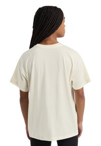 Cream cotton t-shirt with short sleeves and a relaxed fit. Rear view shows a rounded neckline and smooth texture without designs.