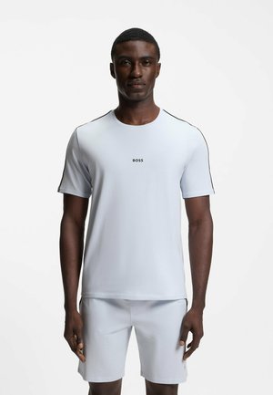 T-shirt sportivo azzurro chiaro con maniche corte, colletto rotondo, dettagli neri sulle spalle e logo centrale "BOSS" sul petto.