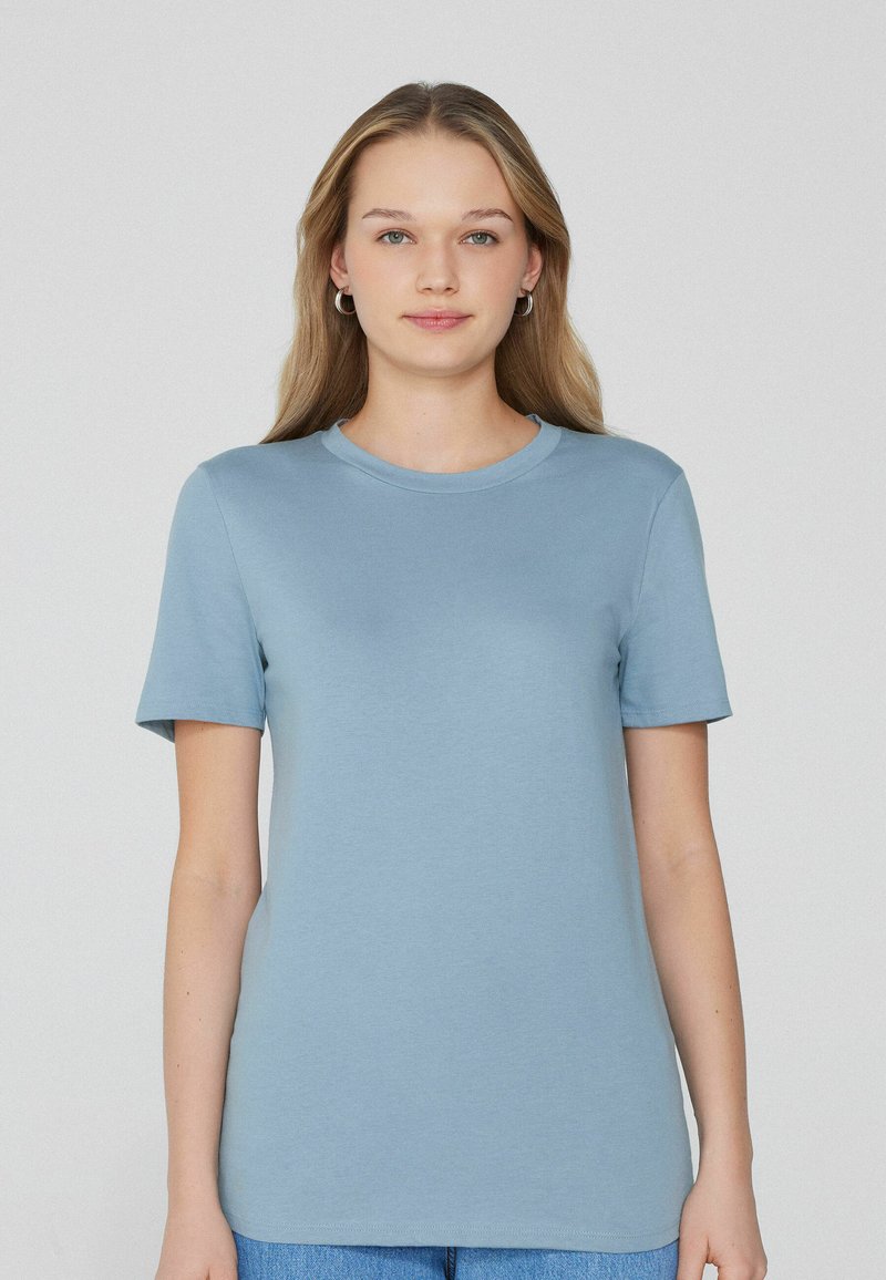 Světle modré tričko s krátkým rukávem vyrobené z měkkého materiálu. Má kulatý výstřih a volný střih, bez vzorů nebo akcentů.