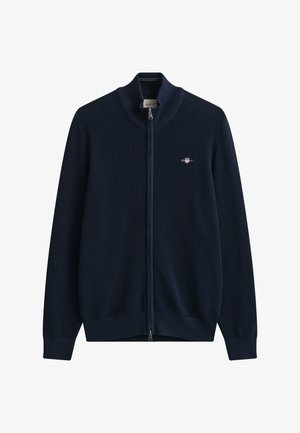 Pull tricoté bleu marine zippé intégralement, avec poignets et col côtelés, avec un petit logo brodé sur la poitrine.