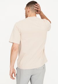 Kortærmet, beige t-shirt lavet af blødt stof, med rund hals og afslappet pasform, lige kant og minimale sømme.