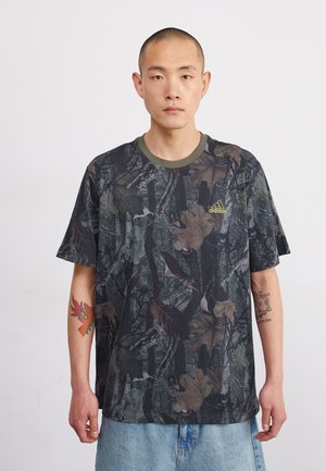 T-shirt s kamuflažno vzorcem v temno zelenih, rjavih in črnih odtenkih; okrogla olivno zelena ovratnica; Adidasov logo v svetlo rumeni barvi; kratke rokave.