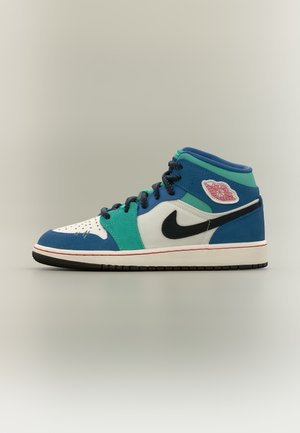 Baskets montantes Nike Air Jordan avec panneaux bleus, bleu-vert, blancs, swoosh noir, écusson logo rouge et lacets noirs sur fond neutre.
