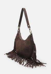 Bruine suède handtas met een ronde vorm, een franjes detail langs de onderkant en een korte schouderband met gouden hardware accenten.