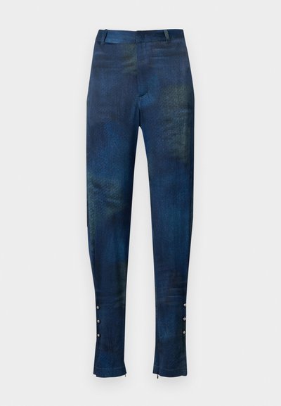 Blue and green patterned trousers with a slim fit, featuring a smooth texture and decorative button accents at the ankle.