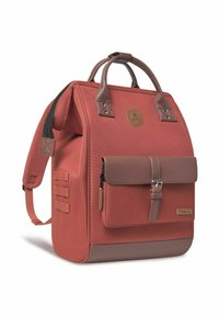 Roter Stoffrucksack mit braunen Lederakzenten, ausgestattet mit einer Fronttasche mit Schnalle, zwei oberen Griffen und verstellbaren Schulterriemen.