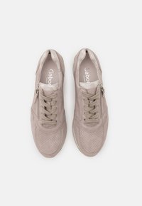 Beige sneakers with perforated suede, lace-up design, and side zippers. Cushioned insoles and rubber soles for comfort and traction.