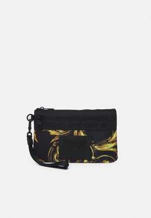 Czarna torebka na nadgarstek z żółtym wzorem w stylu barokowym, przednią kieszenią na zamek i tłoczonym logo "Versace Jeans Couture".