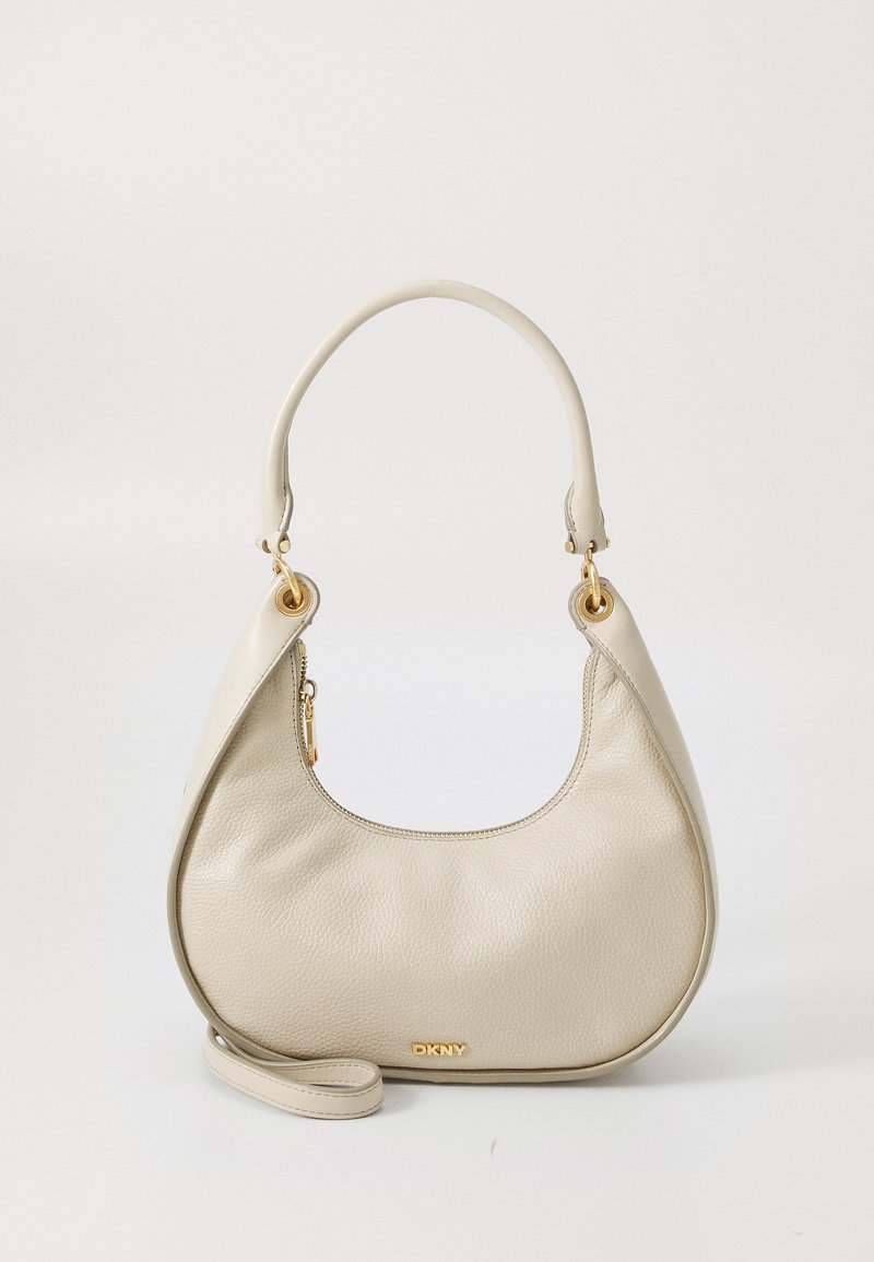 Borsa a mano in pelle beige con texture a ciottoli, dalla forma curva, manico superiore e hardware in tono oro. Presenta una chiusura con zip e una tracolla rimovibile.