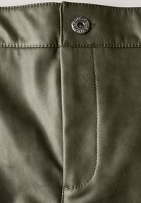 Olivgrön konstläder med en jämn textur, med en silverknappstängning och synlig sömnad längs sömmarna.