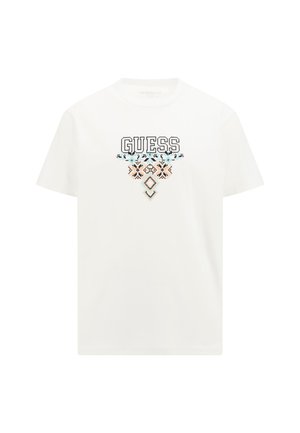 Bijela pamučna majica s "GUESS" logotipom u debelom crnom fontu, s dekorativnim geometrijskim uzorcima u plavoj i breskvastoj boji ispod logotipa.