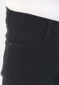 Jeans de denim negro con una textura suave, que cuentan con un bolsillo frontal, un bolsillo trasero y detalles de costura sutiles a lo largo de las costuras.