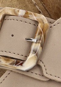 Cintura in finta pelle beige con una fibbia rettangolare marmorizzata nei toni marroni e crema. La fibbia ha un elegante ardiglione in argento, con cuciture visibili.