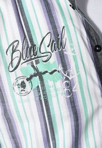 Kragenhemd mit grünen, lila und schwarzen vertikalen Streifen. "Blue Sail" in Schreibschrift aufgedruckt; umfasst nautische Grafiken und Logo-Details.