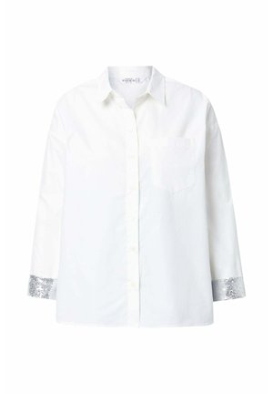Camisa de algodón blanca con botones en la parte delantera, mangas largas, un bolsillo en el pecho y puños con lentejuelas plateadas. Textura suave y corte relajado.
