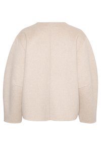 Bežinė vilnos mišinio striukė su apvaliu kaklu, kritusiomis petukais ir apvaliais kraštais. Audinys atrodo minkštas ir tekstūruotas. Nėra matomų užsegimų.