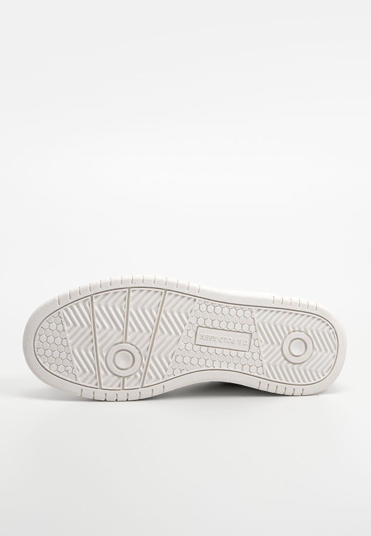 Semelle de basket blanche avec des crampons à motif. Présente des détails circulaires et hexagonaux, un bord plat et une marque en relief. Matériau lisse en caoutchouc.