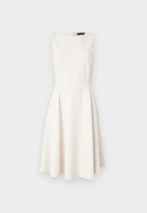 En hvit, ermeløs kjole med innsvingt liv og utvidet skjørt. Jevn stoff, rund halslinning og glidelås bak.