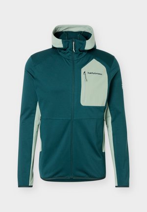 Tume roheline lukuga jakk helesinise rohelise kapuutsi, külgpaneelide ja rindkere taskuga, millel on "Peak Performance" logo.