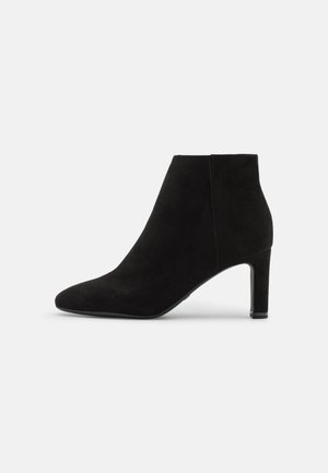 Black suede ankle boot with pointed toe and mid-height block heel, viewed from the side on a white background.
