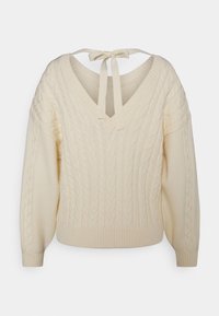 Pull tricoté couleur crème avec motif torsadé, col en V et détail noué à l'arrière. Manches longues et ourlet côtelé complètent le design.