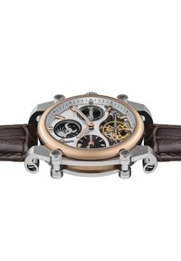 Bruine leren bandhorloge met een ronde zilveren en roségouden kast. Het skeleton-dial toont ingewikkelde tandwielen, zwarte accenten en een zon/maan motief.