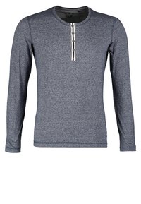 Tummansininen pitkähihainen paita, joka on valmistettu teksturoidusta kankaasta. Siinä on pyöreä pääntie ja kolme nappia käsittävä napitus. Slim fit -malli.