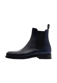 Botas Chelsea de cuero marino con paneles elásticos en los laterales, punta redonda y una pestaña en la parte trasera. Suela plana con un acabado limpio.